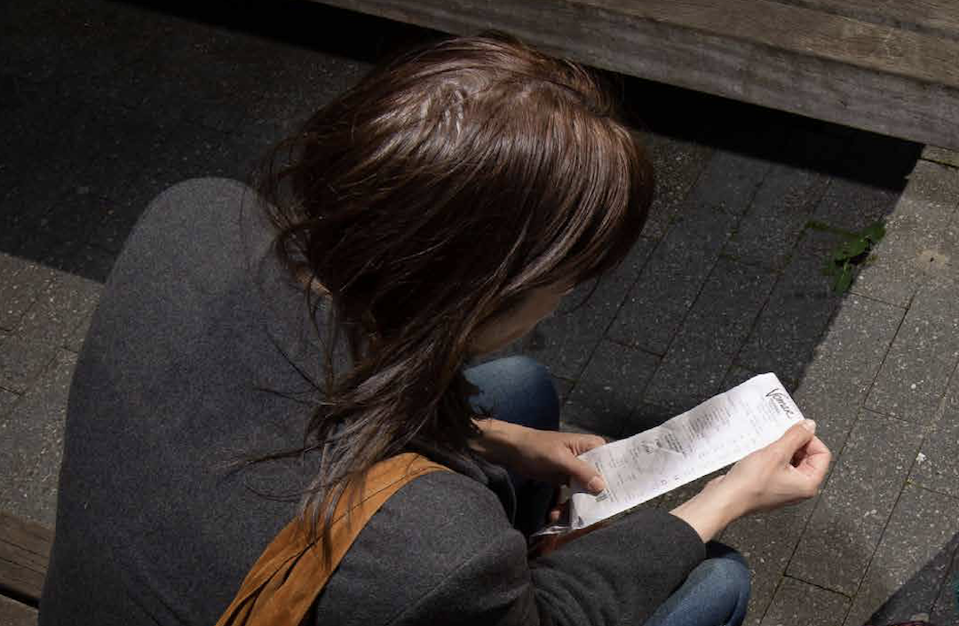 Afbeelding uit Beurs (dame kijkt naar kassabon).png